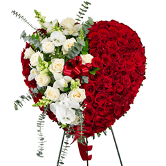 A standing solid heart composed of all red roses with a streak of white roses and orchids